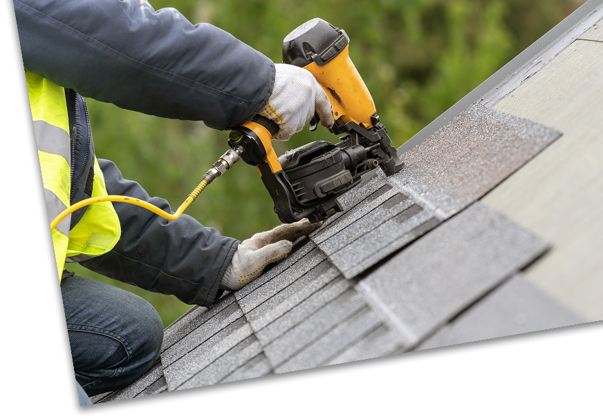 Roofer using nail gun on roof